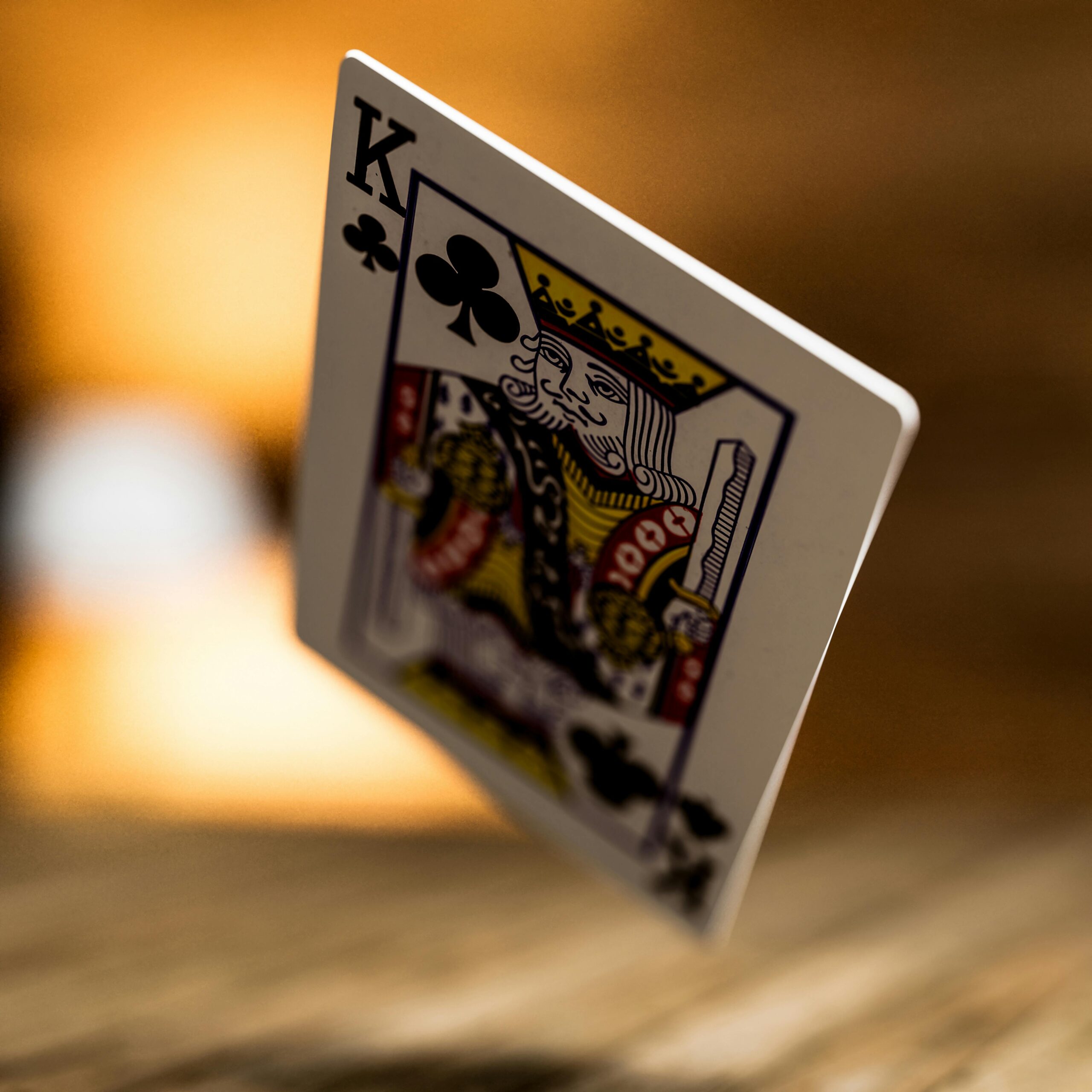 Artistic close-up of the King of Clubs playing card with blurred background.